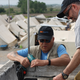 Kevin MacRitchie and Sam Perales install a satellite dish at Giannitsa camp in northern Greece.